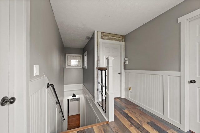 staircase with hardwood / wood-style flooring and a textured ceiling