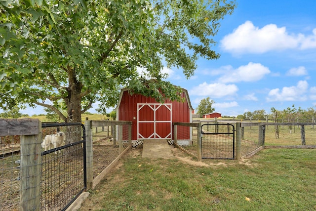 view of outbuilding with a lawn and a rural view