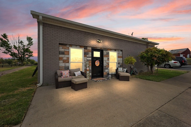 back house at dusk featuring a yard