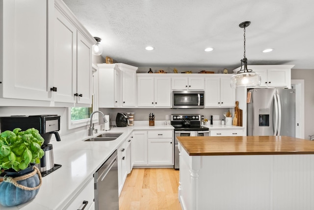 kitchen with stainless steel appliances, white cabinets, and sink