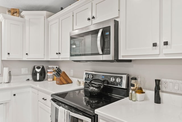 kitchen with white cabinets, a textured ceiling, and appliances with stainless steel finishes