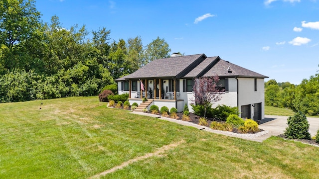 view of front of house featuring a garage, covered porch, and a front yard