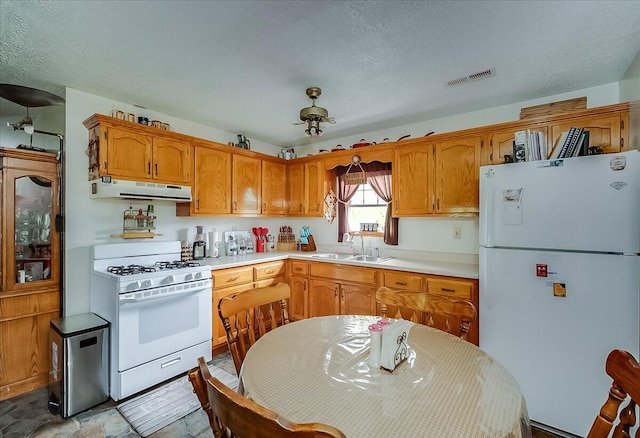 kitchen featuring white appliances, a textured ceiling, and sink