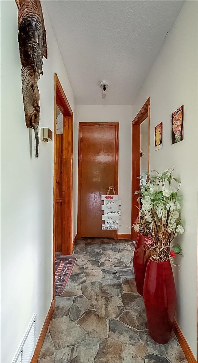 hall with a textured ceiling