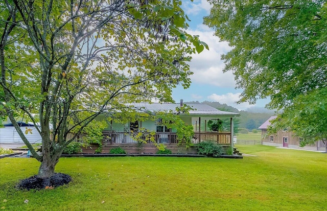 rear view of property with a lawn and covered porch