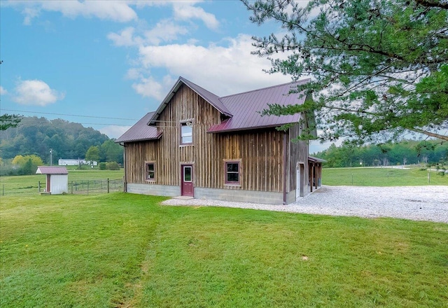 back of house with a lawn and an outbuilding