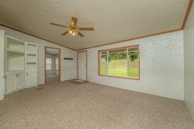 interior space featuring crown molding, vaulted ceiling, carpet flooring, ceiling fan, and a textured ceiling