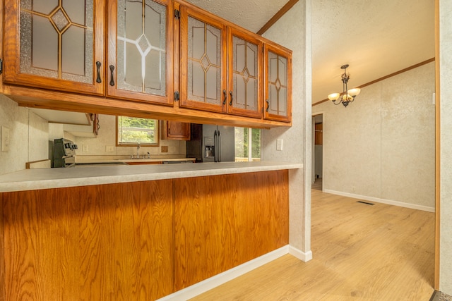 kitchen featuring ornamental molding, stove, light hardwood / wood-style flooring, and a notable chandelier