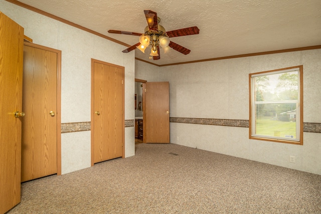 unfurnished bedroom featuring ornamental molding, a textured ceiling, ceiling fan, and carpet floors