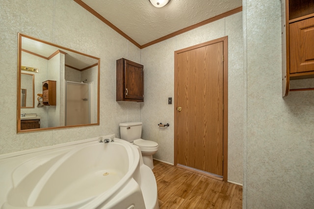 bathroom with plus walk in shower, toilet, wood-type flooring, ornamental molding, and a textured ceiling