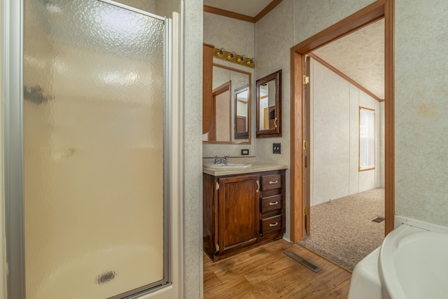 bathroom with crown molding, vanity, hardwood / wood-style flooring, and separate shower and tub