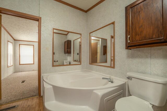 bathroom with wood-type flooring, toilet, a bathtub, and crown molding