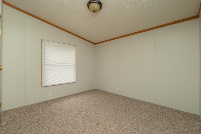 carpeted spare room featuring a textured ceiling, crown molding, and vaulted ceiling