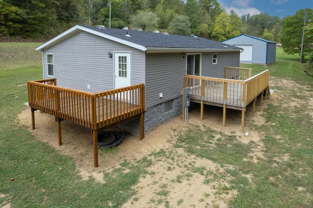 rear view of property featuring a wooden deck and a lawn