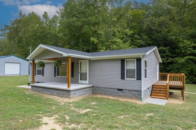 view of front facade with an outbuilding, a garage, and a front lawn