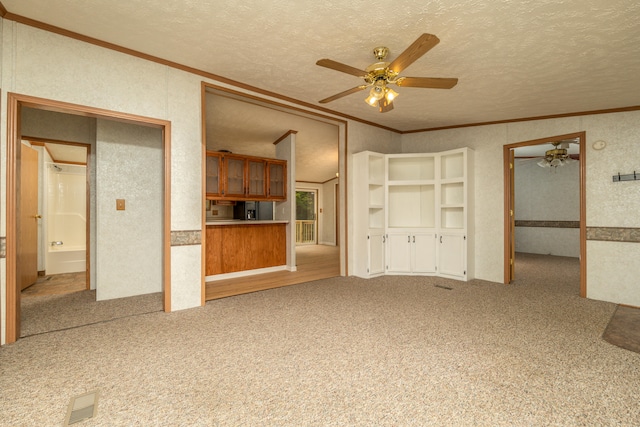 unfurnished living room with ornamental molding, a textured ceiling, ceiling fan, and carpet flooring