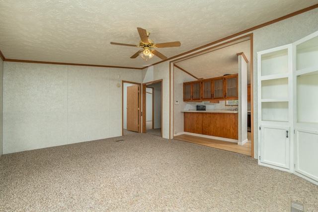 unfurnished living room featuring ceiling fan, light colored carpet, and a textured ceiling