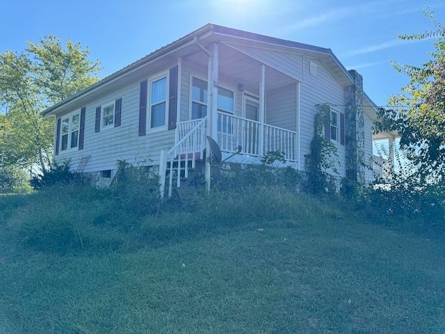 view of front of home with a porch and a front lawn