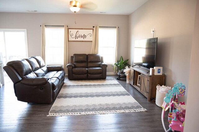 living room featuring dark wood-type flooring and ceiling fan