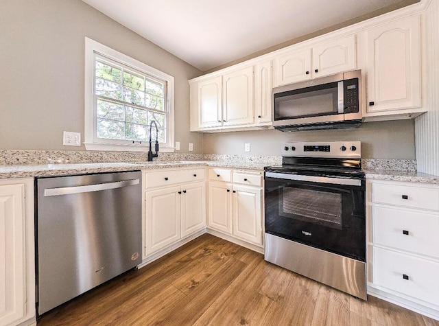 kitchen featuring white cabinetry, light hardwood / wood-style flooring, and stainless steel appliances