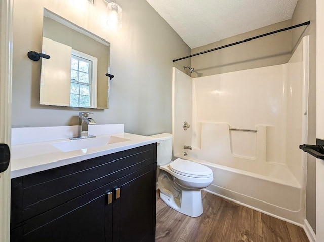 full bathroom featuring a textured ceiling, vanity, toilet, hardwood / wood-style flooring, and washtub / shower combination