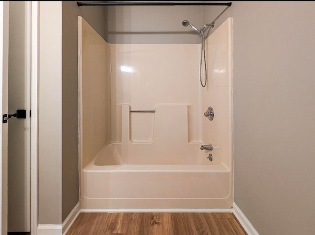 bathroom featuring hardwood / wood-style floors and shower / washtub combination