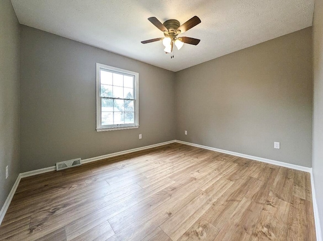 unfurnished room with light wood-type flooring, ceiling fan, and a textured ceiling