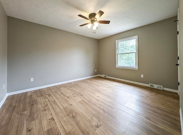 spare room with a textured ceiling, light hardwood / wood-style flooring, and ceiling fan