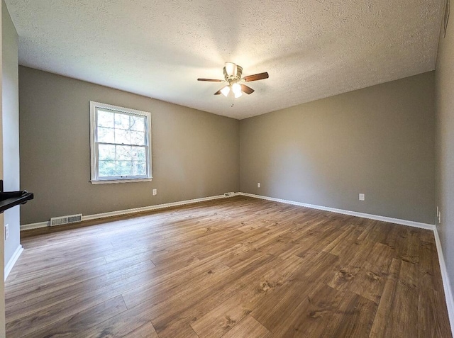 spare room with a textured ceiling, ceiling fan, and hardwood / wood-style floors