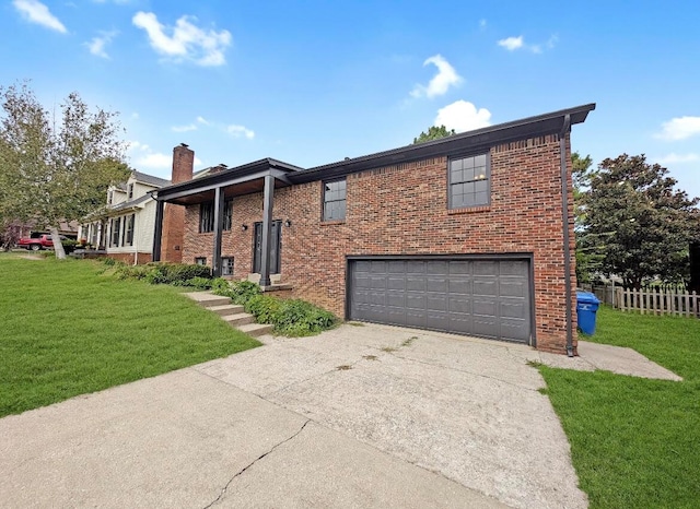 raised ranch featuring a garage and a front lawn