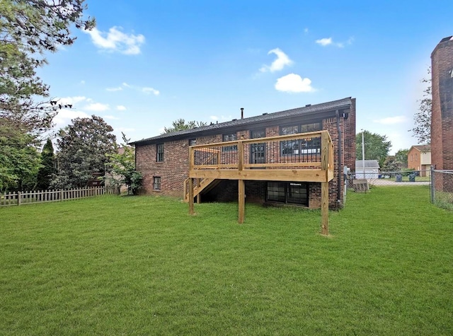 rear view of house featuring a yard and a deck