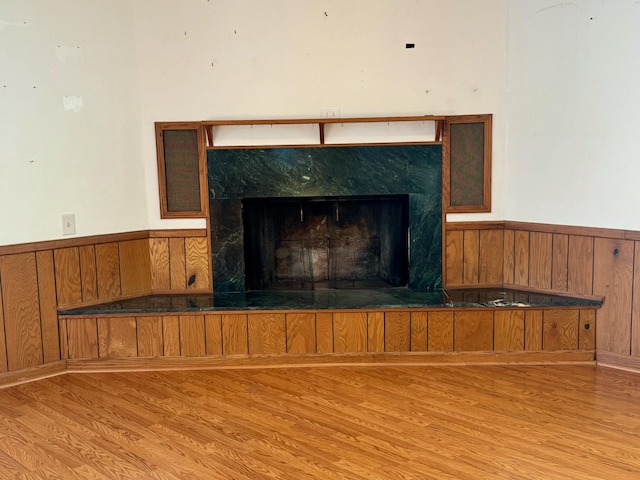 interior details with wooden walls, a premium fireplace, and hardwood / wood-style floors