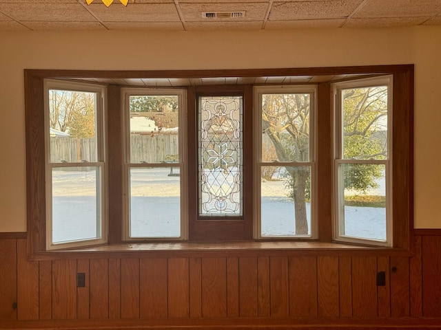 entryway featuring a drop ceiling and wood walls