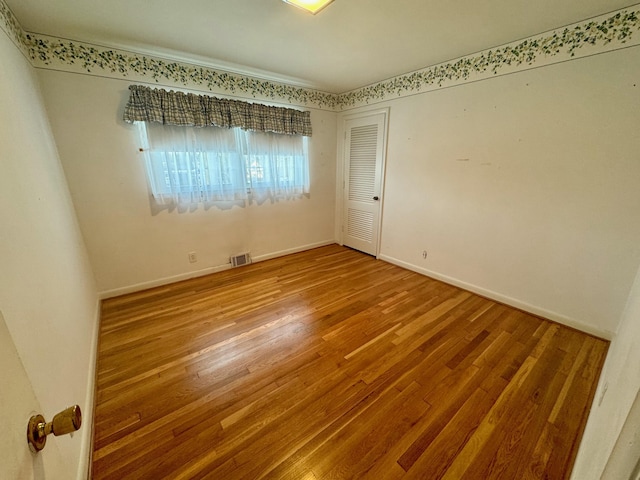 unfurnished room with hardwood / wood-style floors