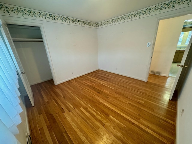 unfurnished bedroom featuring wood-type flooring and a closet