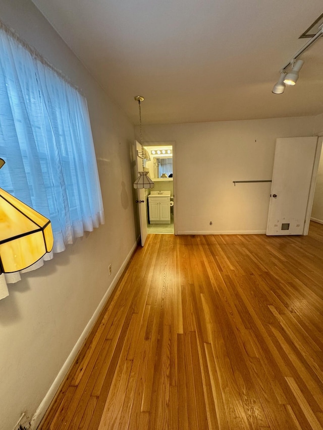 spare room featuring hardwood / wood-style flooring and track lighting