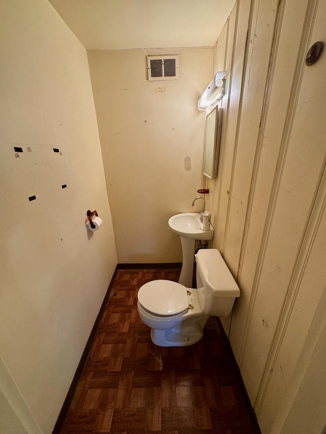 bathroom with parquet flooring and toilet