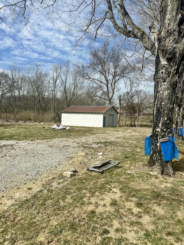 view of yard featuring an outbuilding, a pole building, and a detached garage