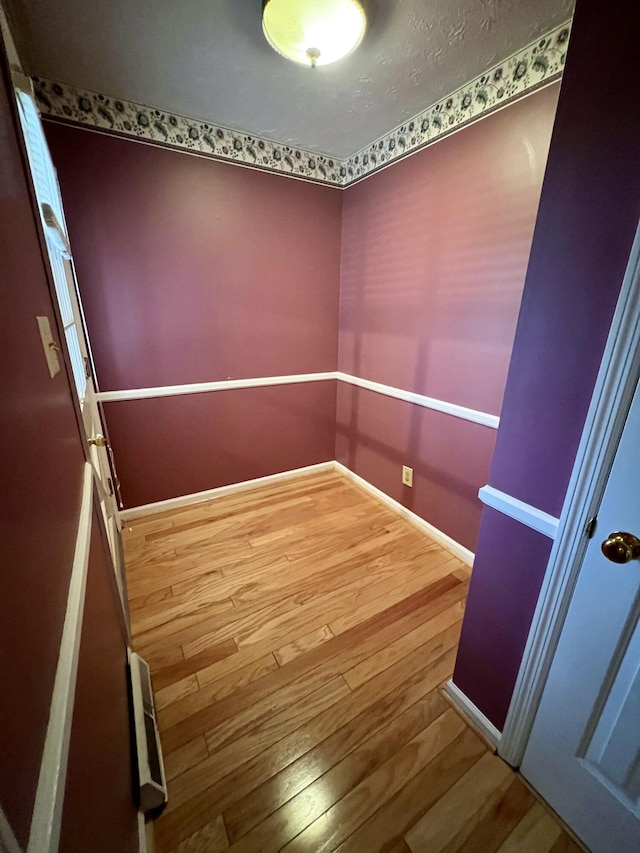 unfurnished room featuring baseboards and wood-type flooring