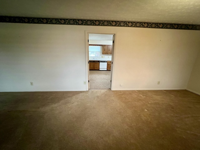 carpeted empty room featuring baseboards and a textured ceiling