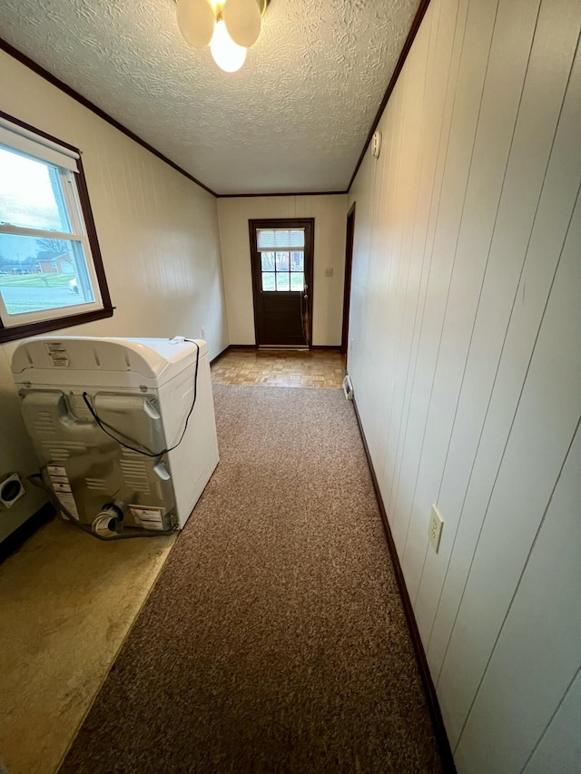 clothes washing area with laundry area, light colored carpet, a textured ceiling, and crown molding