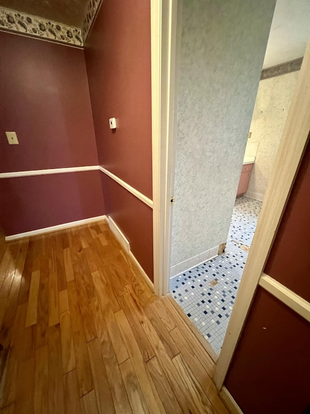 hall featuring baseboards and hardwood / wood-style flooring