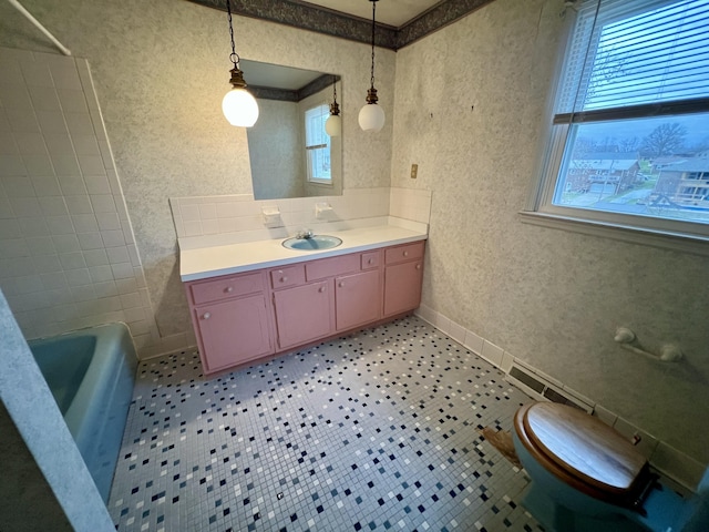 full bathroom featuring a wealth of natural light, visible vents, vanity, and wallpapered walls