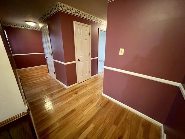 hallway with baseboards and wood finished floors