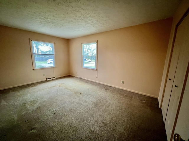 interior space with baseboards, carpet flooring, a textured ceiling, and visible vents