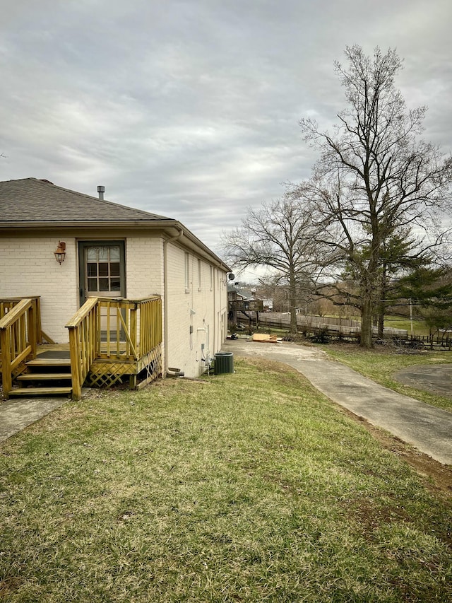 view of yard featuring a wooden deck and central AC