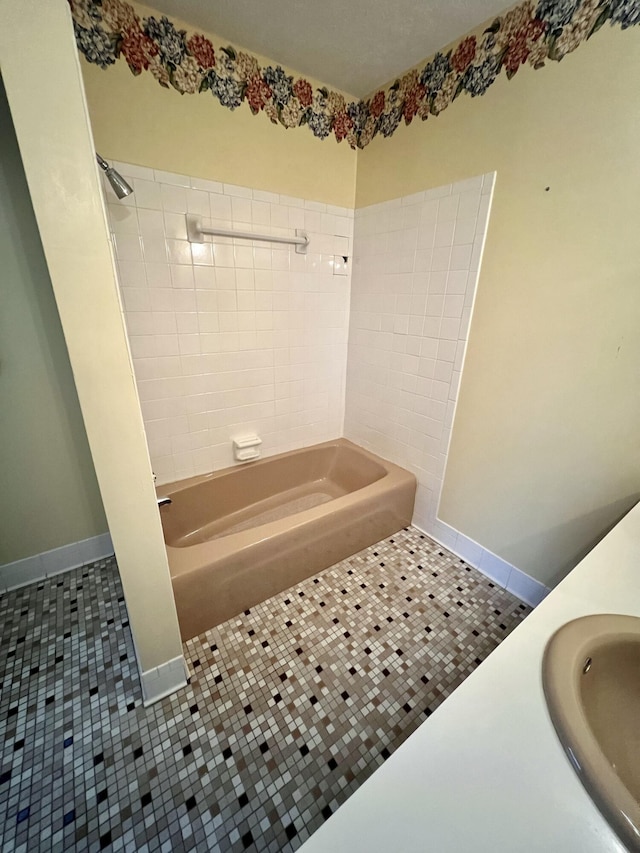 bathroom with tile patterned flooring, shower / tub combination, baseboards, and a sink