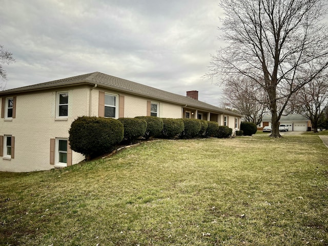 view of property exterior featuring brick siding, a lawn, a chimney, and a garage