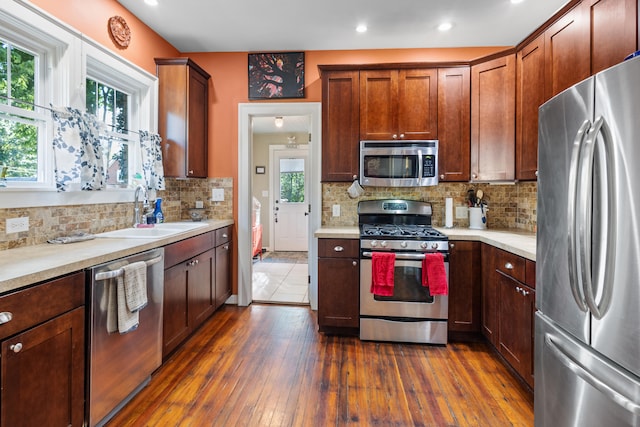 kitchen with stainless steel appliances, dark hardwood / wood-style floors, sink, and backsplash