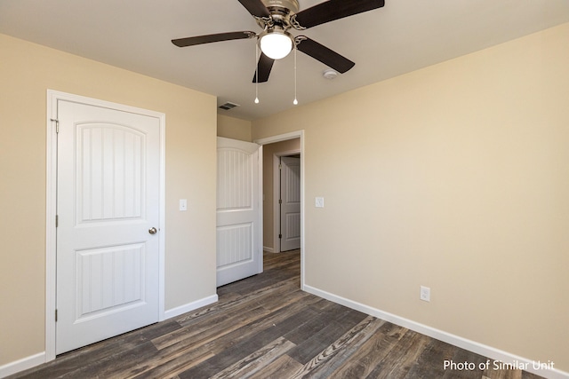 unfurnished bedroom with ceiling fan and dark wood-type flooring